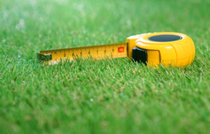 Measuring tape lies on the grass lawn