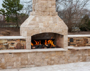 Outdoor stone fireplace with retaining wall
