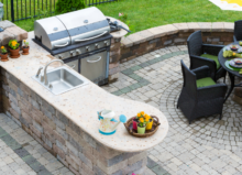 Outdoor stone kitchen with grill and patio