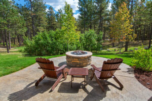 Two chairs are placed around a firepit.